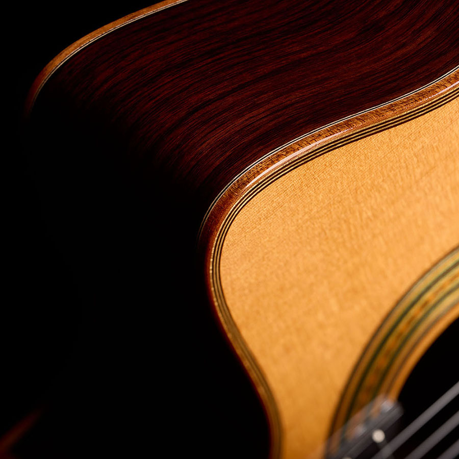 Close-up of the Orchestra CE Pro showing the rosewood side curving into the spruce top edge.