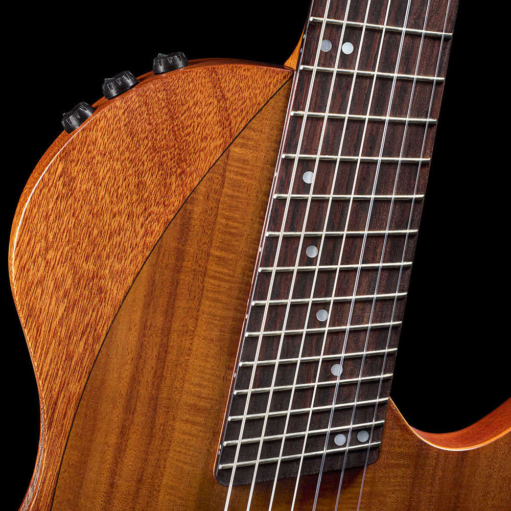 Close-up of the Abasi Stage 7 Acacia's rosewood fretboard and mahogany neck meeting the guitar's ergonomic cutaway body.