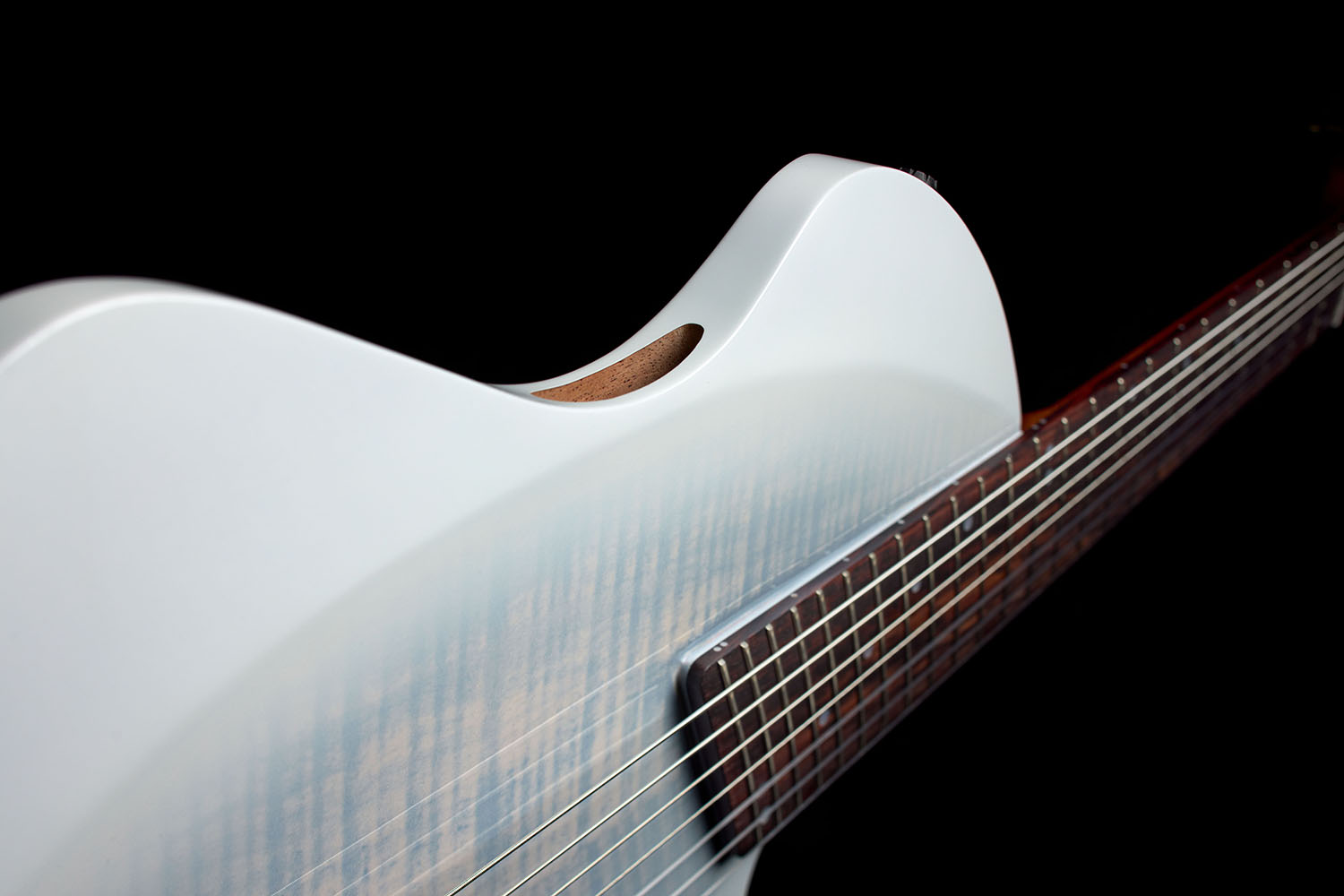 Close-up of the Abasi Stage 7 White Burst's cutaway body and oval side sound hole, showing the flame maple top's figured grain.