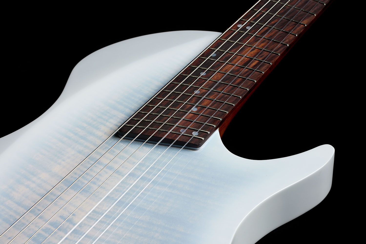 Close-up looking down the Abasi Stage 7 White Burst's neck toward the body, showing the rosewood fretboard's dot markers and the cutaway body.
