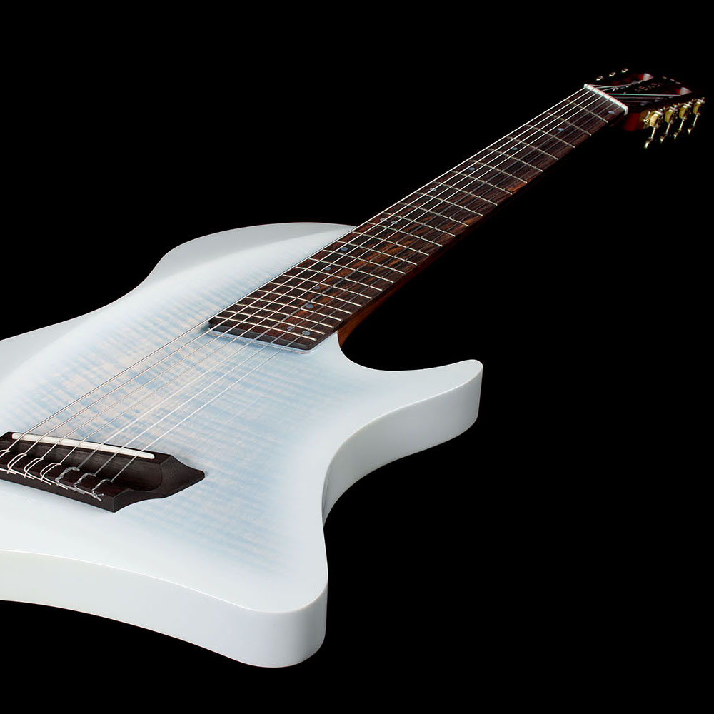Close-up looking up the rosewood fretboard toward the Abasi Stage 7 White Burst's headstock and brass tuners, with the flame maple top visible below.
