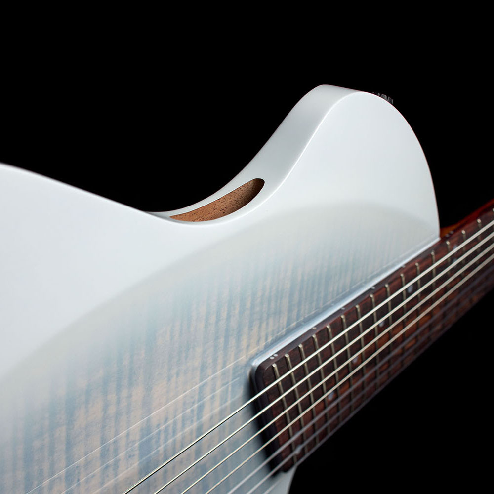 Close-up of the Abasi Stage 7 White Burst's cutaway body and oval side sound hole, showing the flame maple top's figured grain.