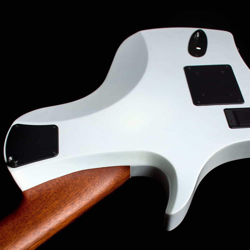 Close-up of the Abasi Stage 7 White Burst's back and neck heel, showing the mahogany neck joint and a black control cover against the white gloss finish.