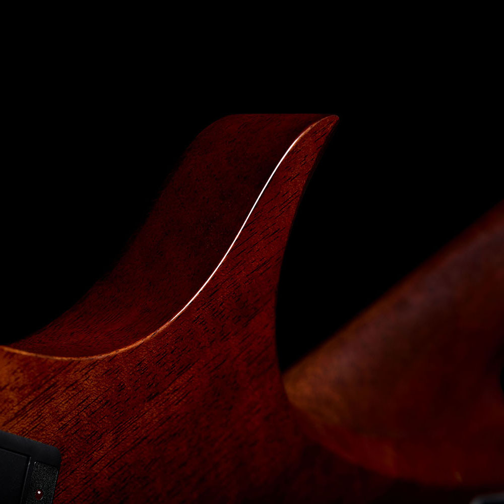 Close-up of the Abasi Stage 7 Ziricote's cutaway horn, showing the glossy mahogany body and rosewood binding.