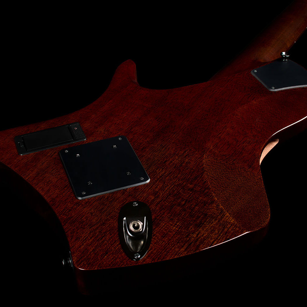 Front-view close-up of the Abasi Stage 7 Ziricote's ergonomic cutaway body, showing the black control cover mounted on the upper bout.