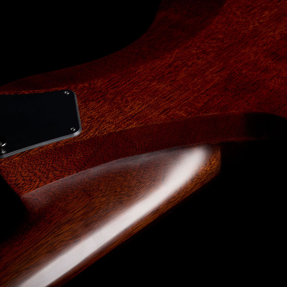 Close-up of the Abasi Stage 7 Ziricote's glossy mahogany body edge and black control cover, showing the smooth curve of the cutaway.