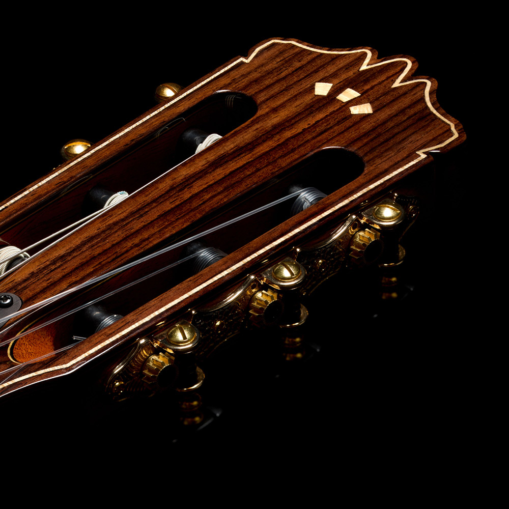 Close-up view of Stage Artist Traditional headstock featuring a flamed maple Córdoba Arches logo thumb